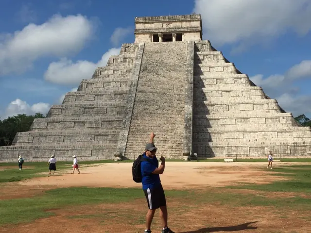 Hassan pointing up at the stepped pyramid of El Castillo at Chichén Itzá in Mexico