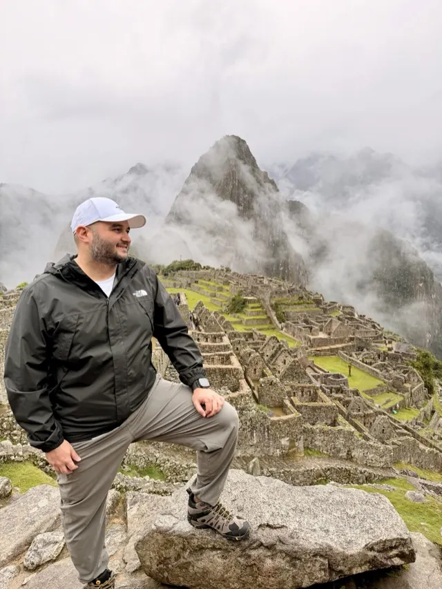 Hassan overlooking the misty stone terraces of Machu Picchu in Peru